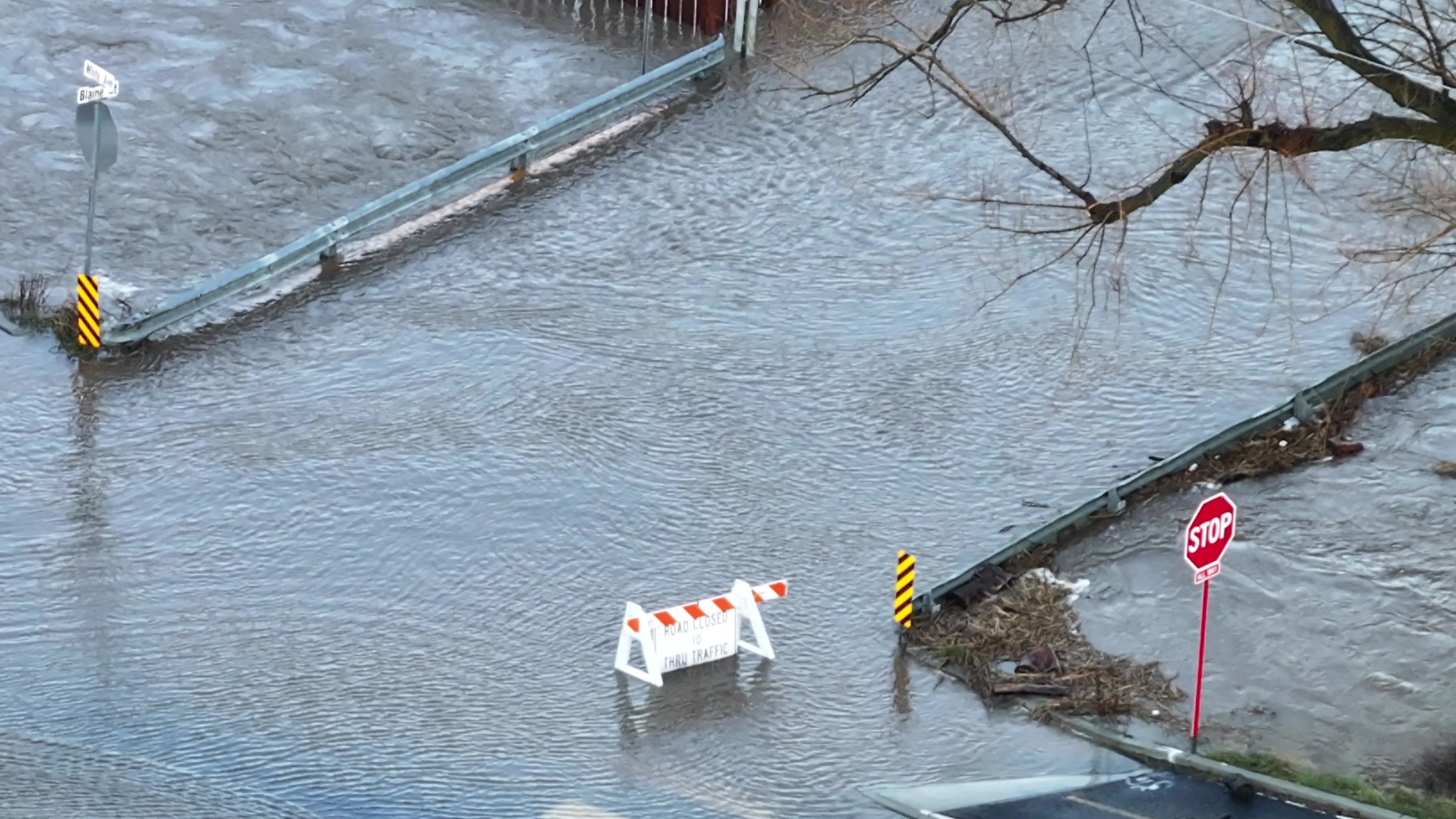 Flooded Urban Street with Barricade and Red Stop Sign - 4K Aerial Drone