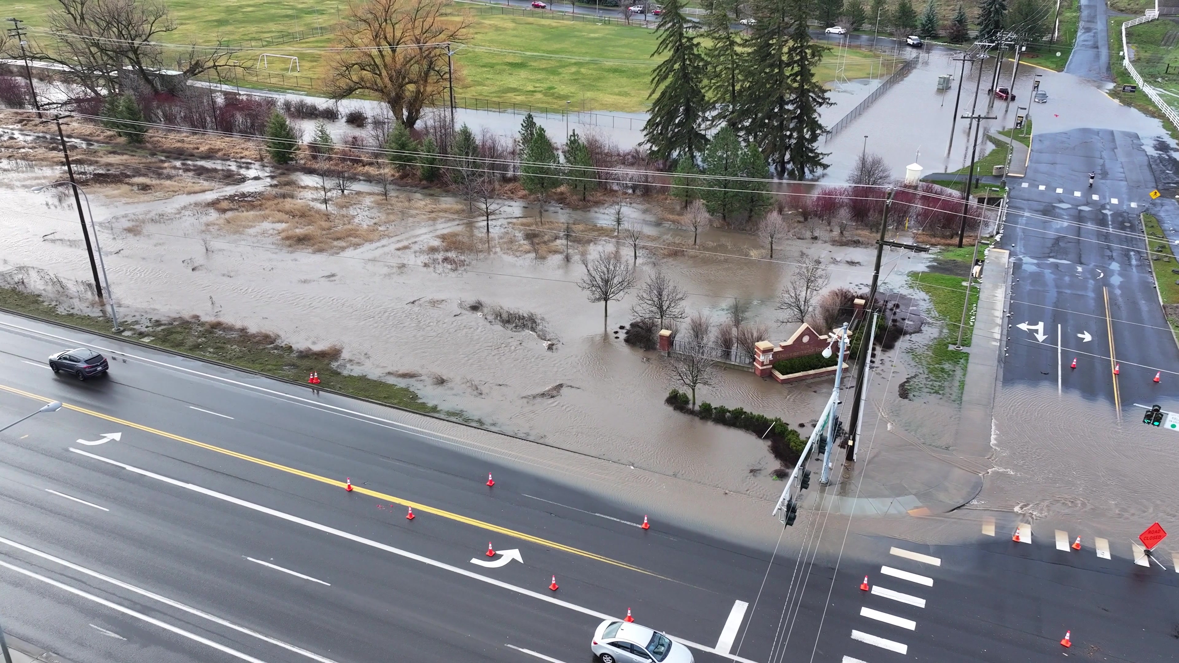 Flooded Urban Street with Traffic Cones and Trees - 4K Aerial Drone