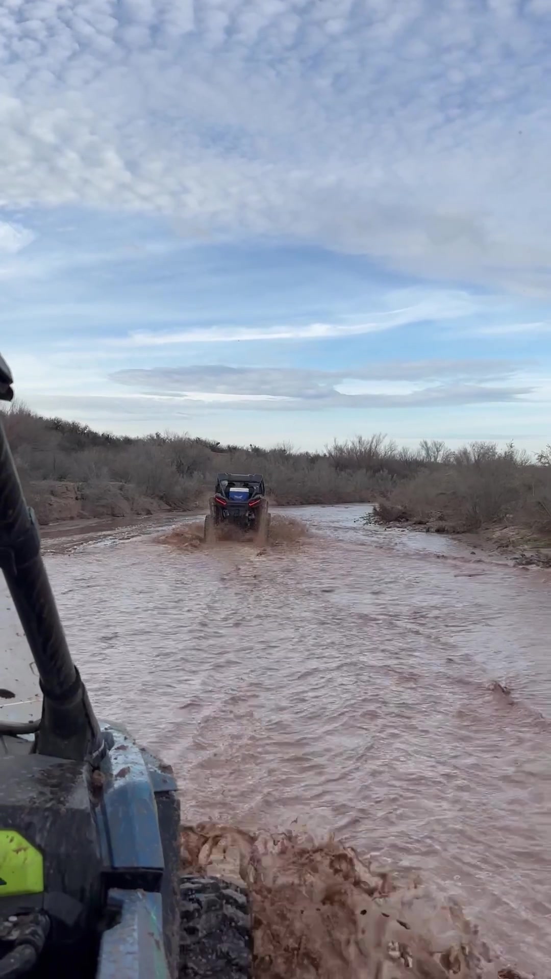 Side-by-side off-road UTVs on a dusty desert trail